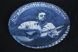 Suzanne Lang. A hand painted ceramic plate featuring a musician Guy Carawan. Guy Hughes Carawan