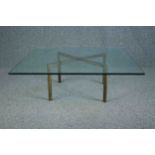 A large glass coffee table with a solid and heavy brass base. H. 34 W.102 D.102 cm.