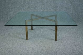 A large glass coffee table with a solid and heavy brass base. H. 34 W.102 D.102 cm.