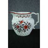 An early 19th century pineapple moulded jug with silver lustre and red enamel floral decoration. H.