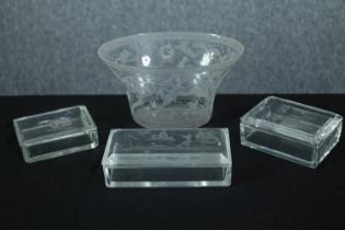 A collection of etched glass including a vase and three lidded glass boxes decorated with a shooting