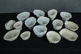 A collection of fifteen early 20th century stoneware and creamware jelly moulds of various