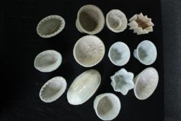 A collection of thirteen early 20th century stoneware and creamware jelly moulds of various designs.