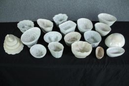 A collection of eighteen early 20th century stoneware and creamware jelly moulds of various designs.