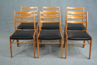 A set of six mid century vintage dining chairs in light beech and faux leather seats.