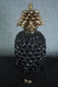 A 1970s vintage ceramic pineapple lamp finished in gilt. A part of the base is loose and in need