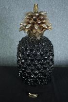 A 1970s vintage ceramic pineapple lamp finished in gilt. A part of the base is loose and in need