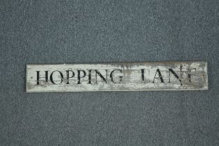 A modern street sign. Hopping Lane. Distressed and aged. H.17 W.106cm.