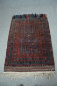 A prayer rug with a sapphire geometric design on a burgundy field. L.125 W.89cm.