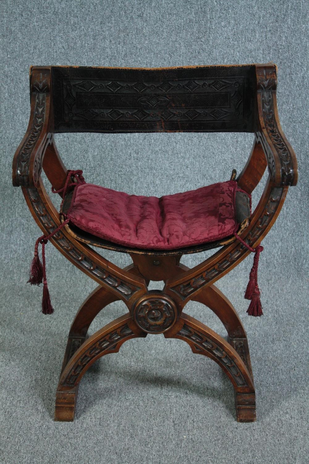 A C.1900 Continental x frame walnut folding armchair with leather seat and back. H.82cm.