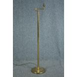 A brass floor standing lamp with adjustable arm. Early to mid twentieth century. H.128 cm.