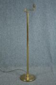 A brass floor standing lamp with adjustable arm. Early to mid twentieth century. H.128 cm.