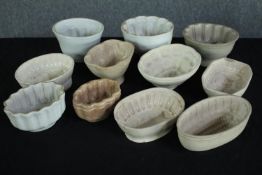 A collection of eleven early 20th century stoneware and creamware jelly moulds of various designs.
