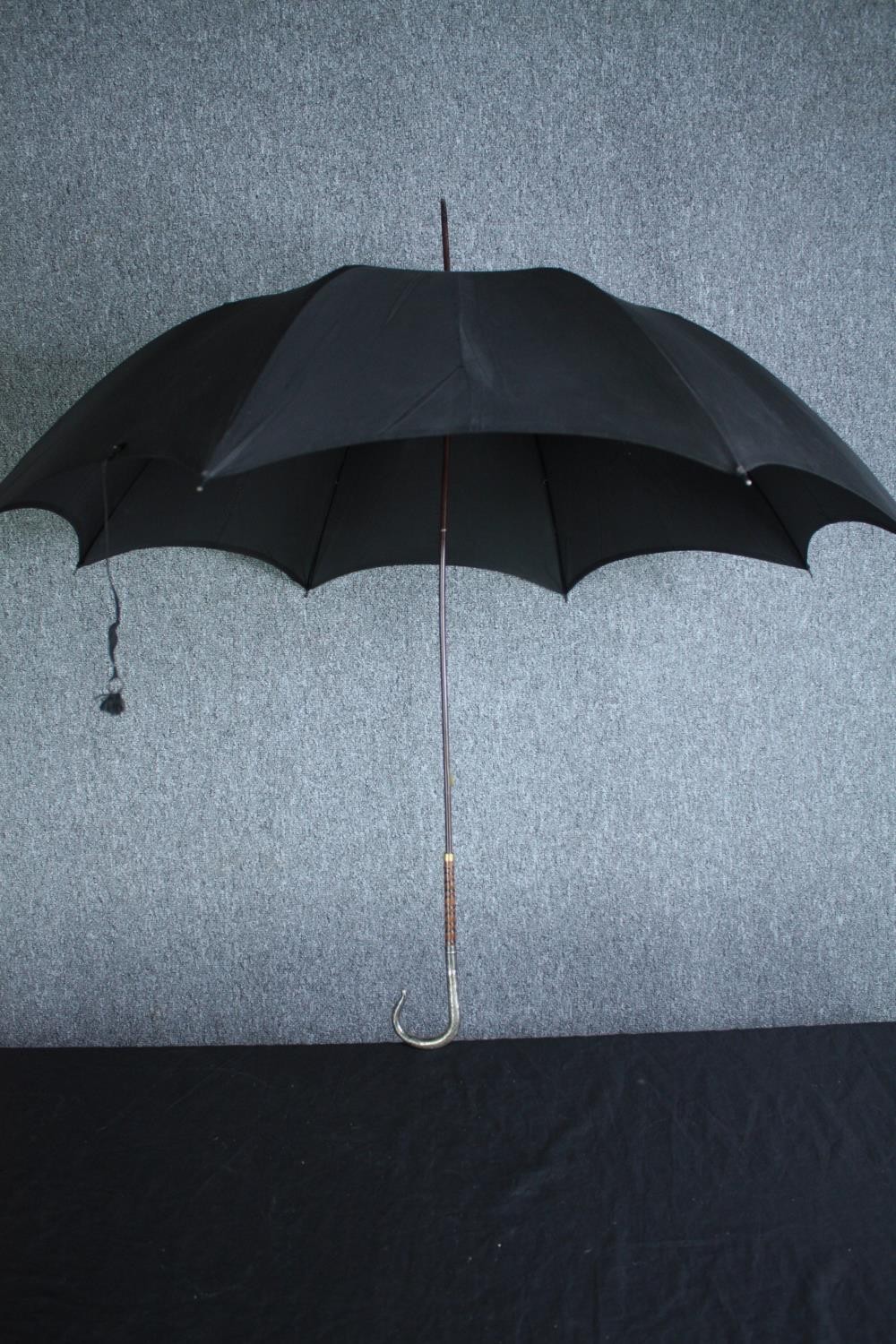 A vintage black silk parasol with hallmarked silver handle and maker's label. L.92cm.