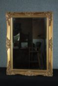 A gilt and gesso Rococo style wall mirror with bevelled plate. H.93 W.63cm.