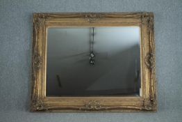 A large mirror with bevelled plate in a foliate gilt decorated frame. H.229 W.160 cm.