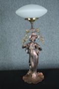 An Art Nouveau style figural lamp, woman holding a garland of flowers with a white glass shade. H.66