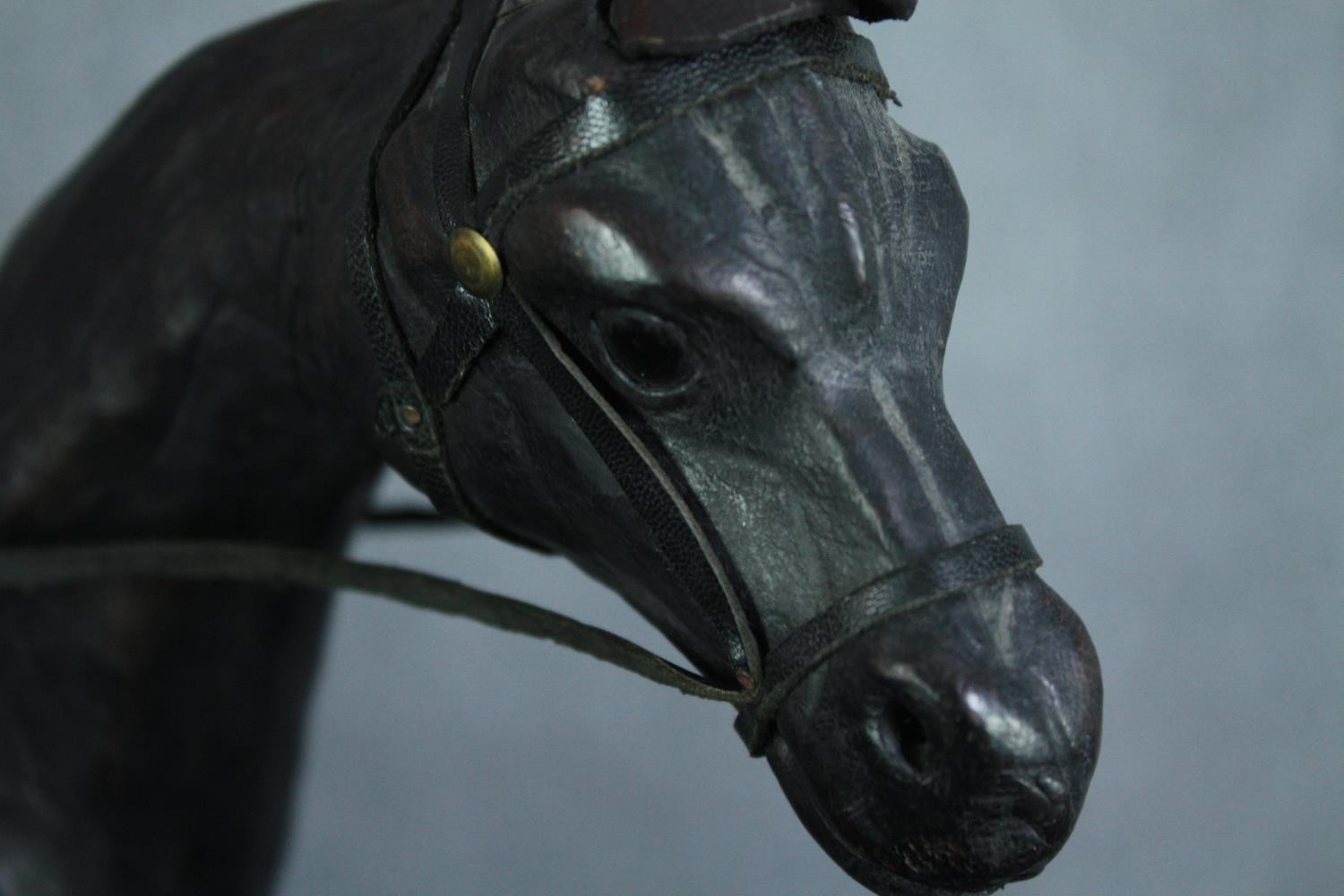 A well carved and detailed horse with leather bridle. Showing signs of past repairs. H.31 W.36 cm. - Image 5 of 5