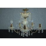 A brass chandelier with four branches of lights and decorated with hanging beaded glass. H.33 Dia.