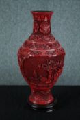 A 20th century Chinese carved cinnabar lacquer baluster vase with a cartouche with precious