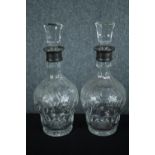 A pair of cut crystal decanters with vine decoration and fitted with silver collars. Hallmarked: