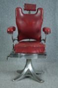 A vintage chromed steel framed barbers chair upholstered in faux red leather. Solid, well crafted