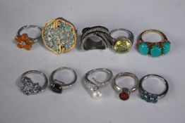A collection of ten silver gem-set rings of various designs. Set with Fire opal, Turquoise,