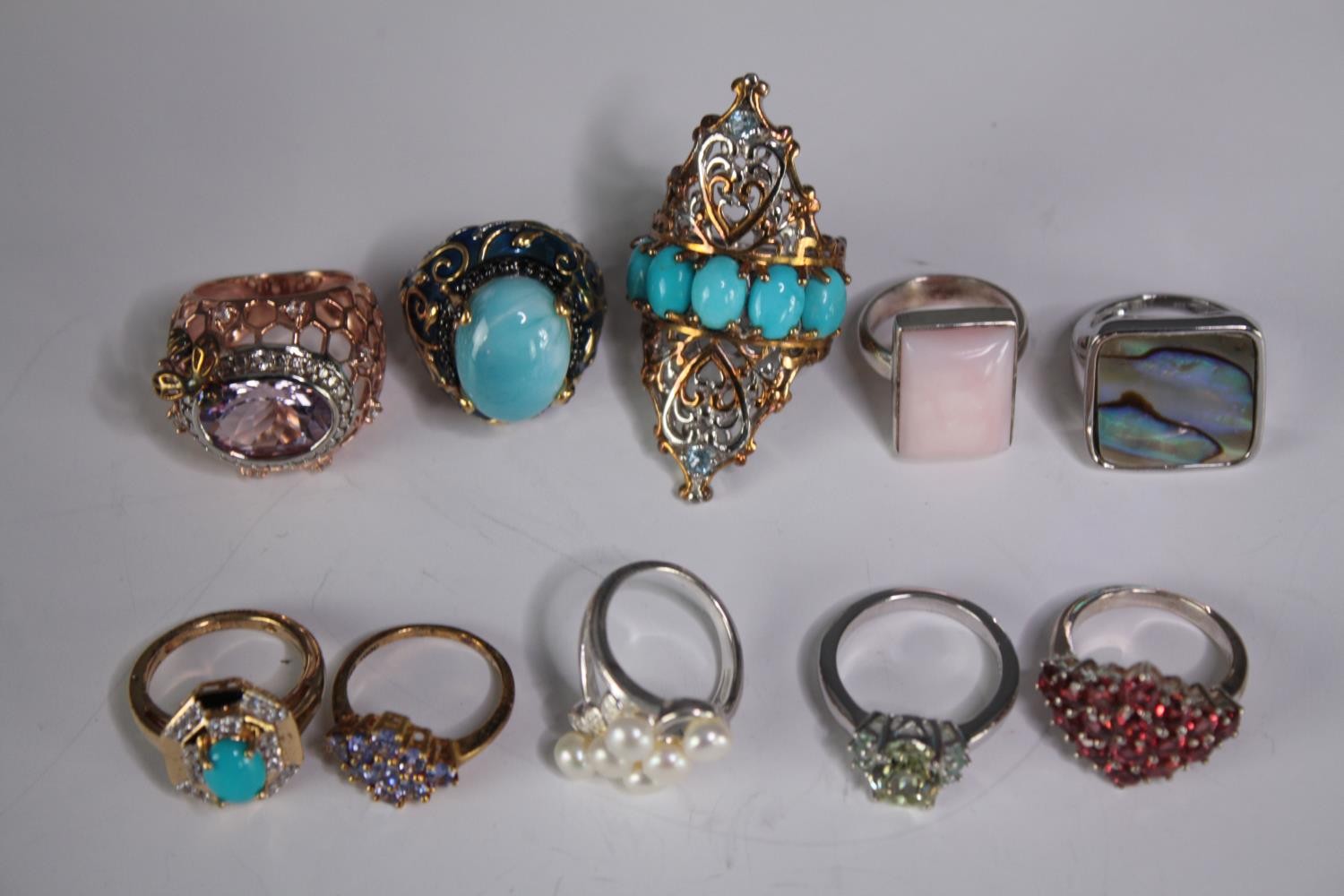 A collection of ten silver gem-set rings of various designs. Set with rose quartz, Turquoise,