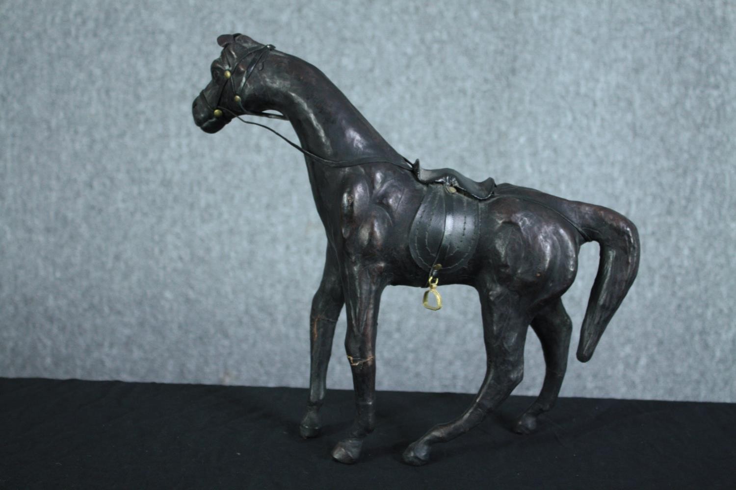 A well carved and detailed horse with leather bridle. Showing signs of past repairs. H.31 W.36 cm. - Image 4 of 5