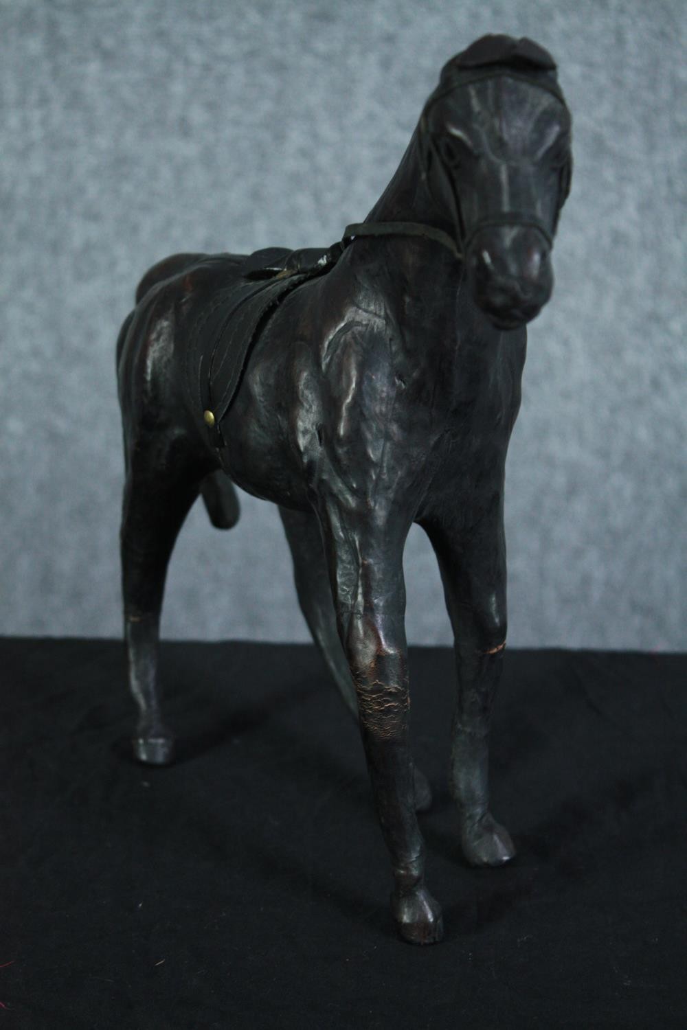 A well carved and detailed horse with leather bridle. Showing signs of past repairs. H.31 W.36 cm. - Image 2 of 5