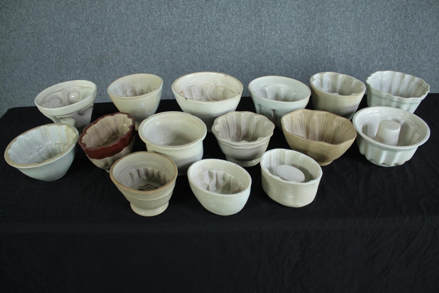 A collection of fifteen early 20th century stoneware and creamware jelly moulds of various