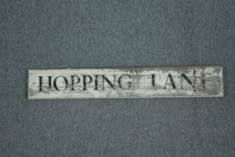 A modern street sign. Hopping Lane. Distressed and aged. H.17 W.106cm.