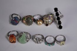 A collection of ten silver gem-set rings of various designs. Set with peridot, pearl, amethyst and