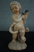 A carved cherub holding the charred remains of a torch or lantern. H.46 cm.