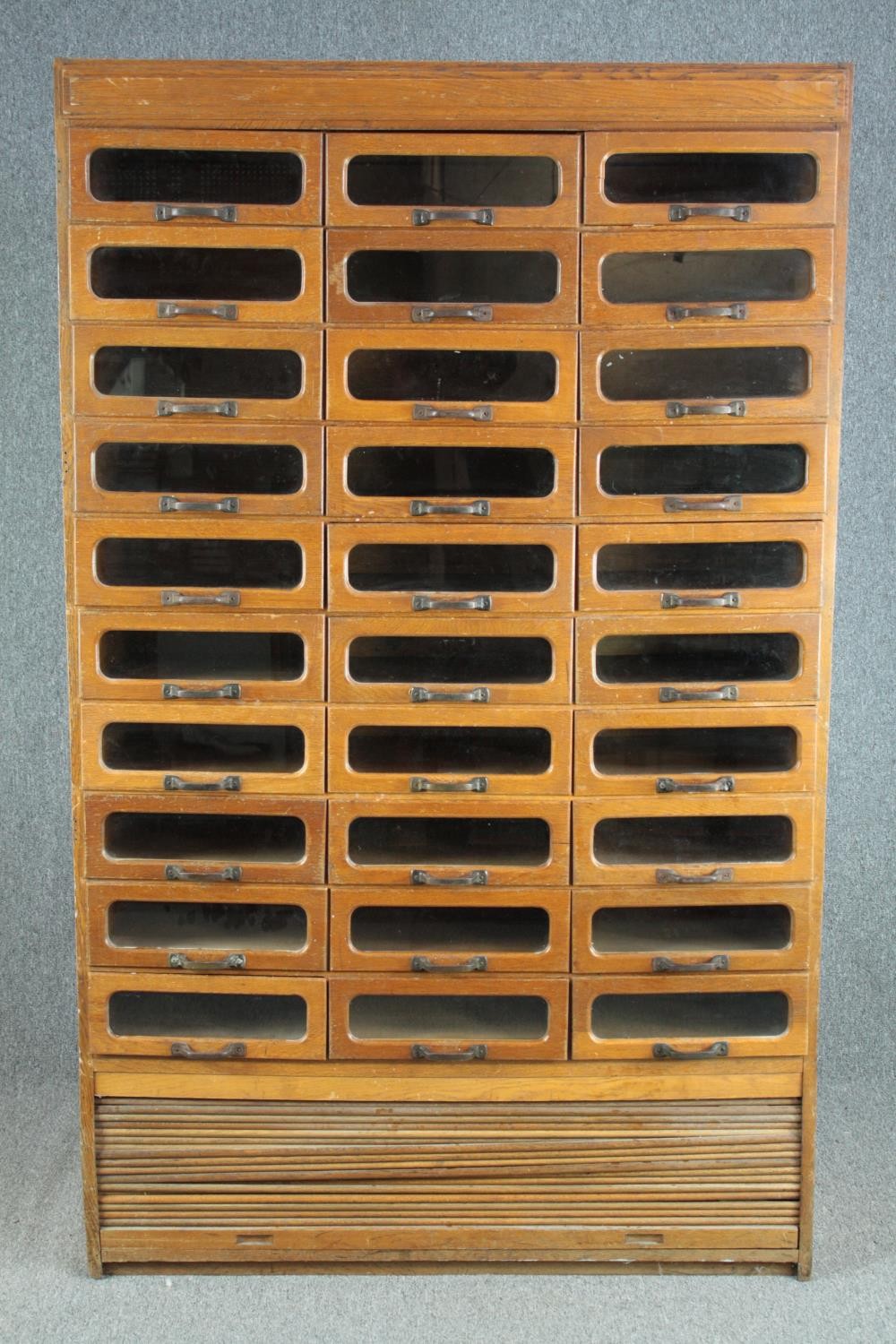 A mid century vintage draper's shop cabinet, full height with a bank of thirty glazed drawers. H.193