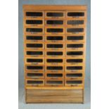 A mid century vintage draper's shop cabinet, full height with a bank of thirty glazed drawers. H.193