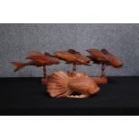 Two carved fish ornaments. Three fish mounted on a wooden stand, stamped Made by Clinton Warren, the