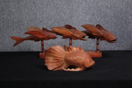 Two carved fish ornaments. Three fish mounted on a wooden stand, stamped Made by Clinton Warren, the