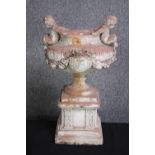 A concrete classical planter mounted with two cherubs on either side. H.46 cm.