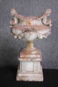 A concrete classical planter mounted with two cherubs on either side. H.46 cm.