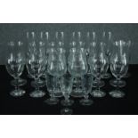 A mixed collection of stemmed glasses. In sets of eight, six, and three with a single sherry