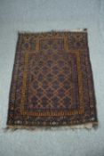 A prayer rug with a repeating geometric pattern within stylised multiple borders. L.124 W.93cm.