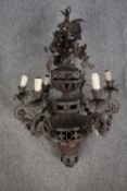 A gothic style chandelier made from iron. With six branches of lights and decorated with oak