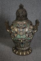 A Moroccan lidded twin handled ceramic urn with metal handles and base. Hand painted ceramic