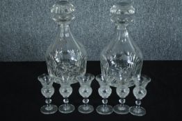 A matching pair of decanters and six small ornate sherry glasses. Twentieth century. H.24cm. (