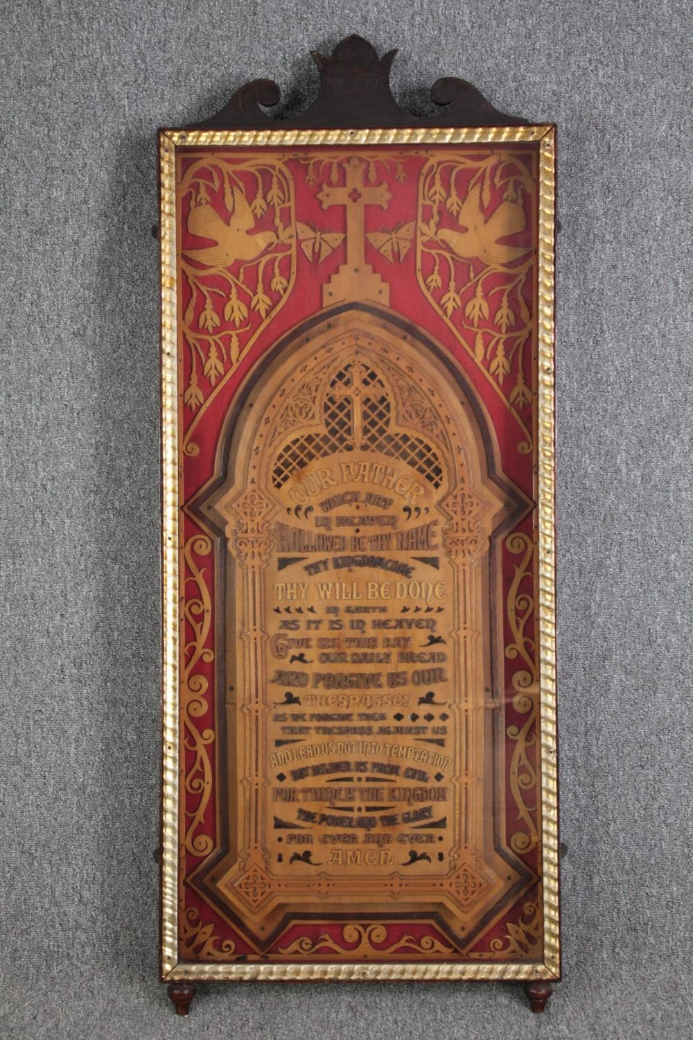 The Lord's Pray carved and mounted behind a red cloth. Framed and illuminated. H.132 W.53cm.