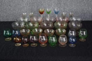 A mixed collection of coloured stemmed glass. Including wine, sherry and cocktail glasses. The