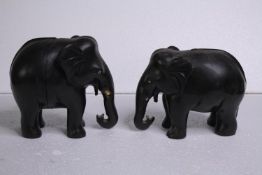 Two carved ebony elephants. Missing their tusks. Early to mid twentieth century. H.15 W.18cm. (