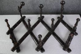 A set of late 19th century concertina action wall mounted coat hooks. H.46 W.77cm.