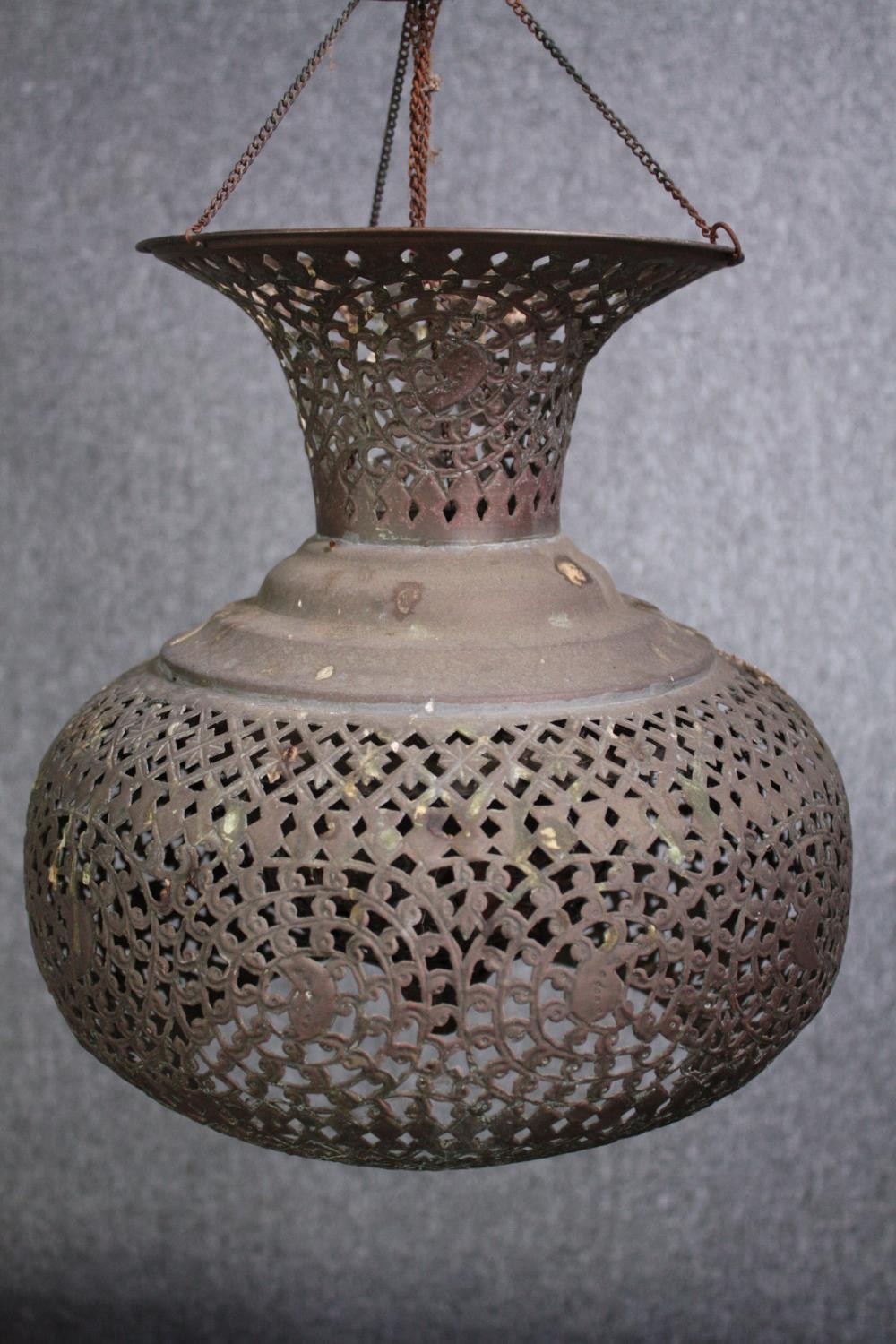 An Arabic pierced copper ceiling lantern. With a chain support. Aged with a patina. H.42cm.